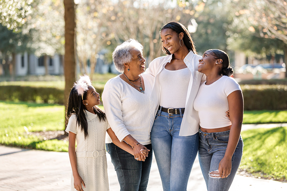family holding hands in the sunshine during a fall photo session